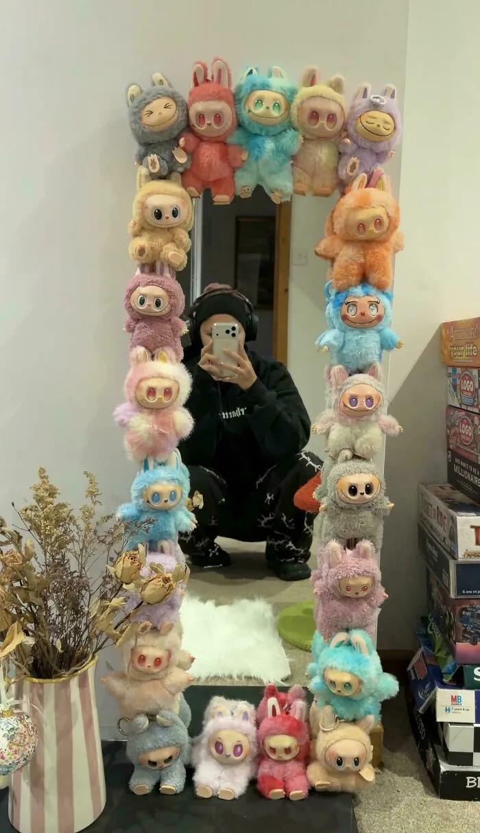 A mirror frame decorated with colorful plush toys, showcasing questionable DIY projects.