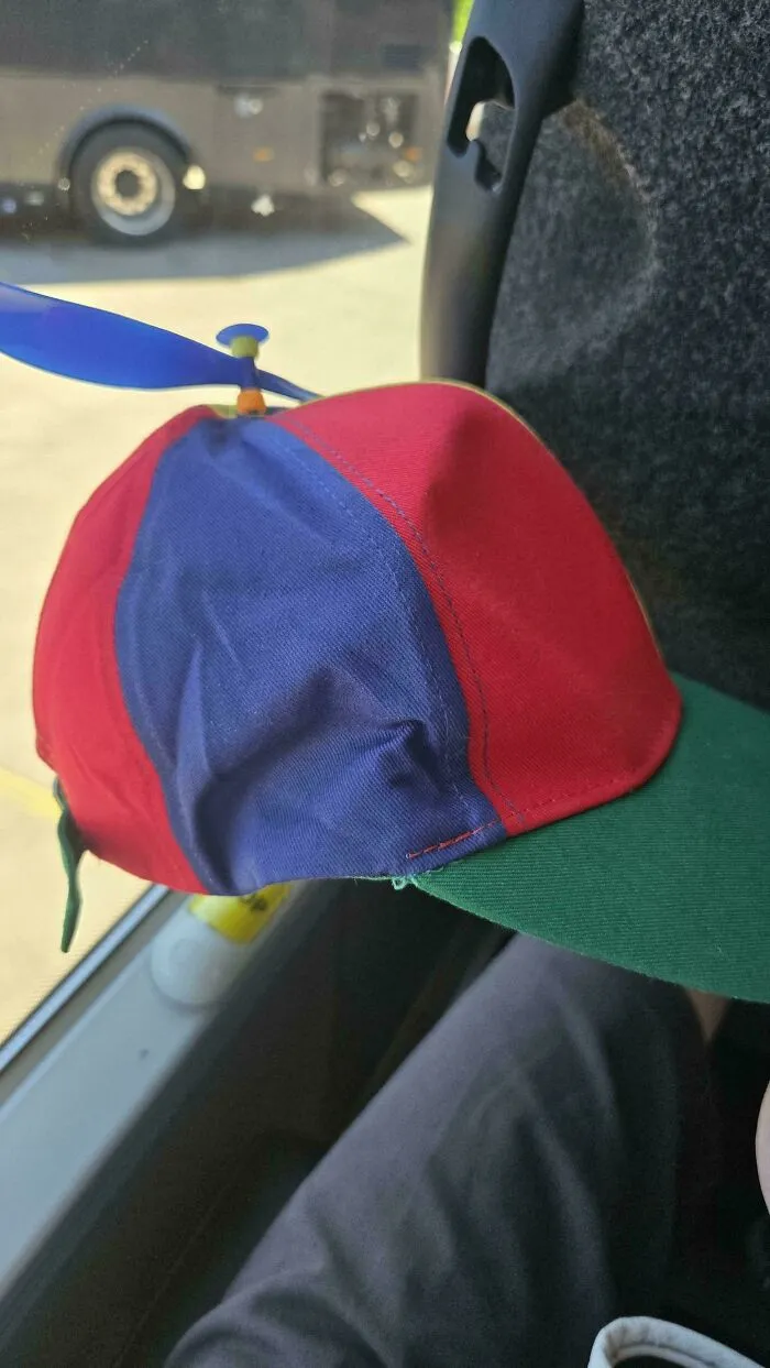 A colorful propeller hat on a bus seat, an amusing image from the “Not Interesting” community.