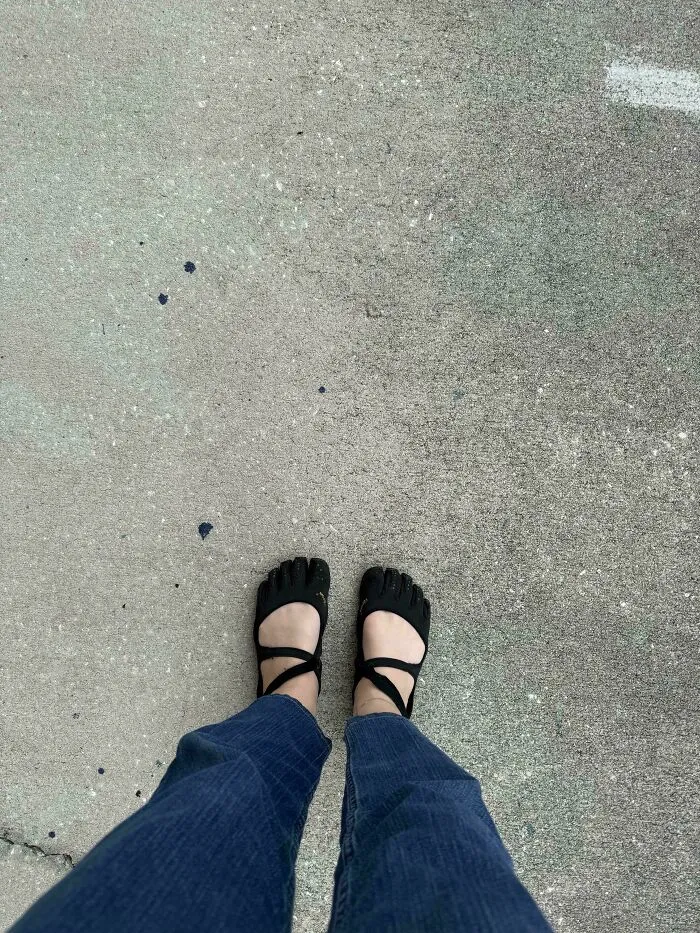 A person in unique toe shoes and blue pants standing on concrete, part of the “Not Interesting” community photos.