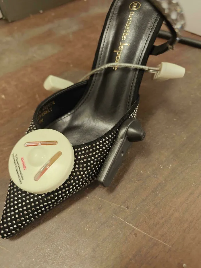 Retail shoe with attached anti-theft security tag on display table