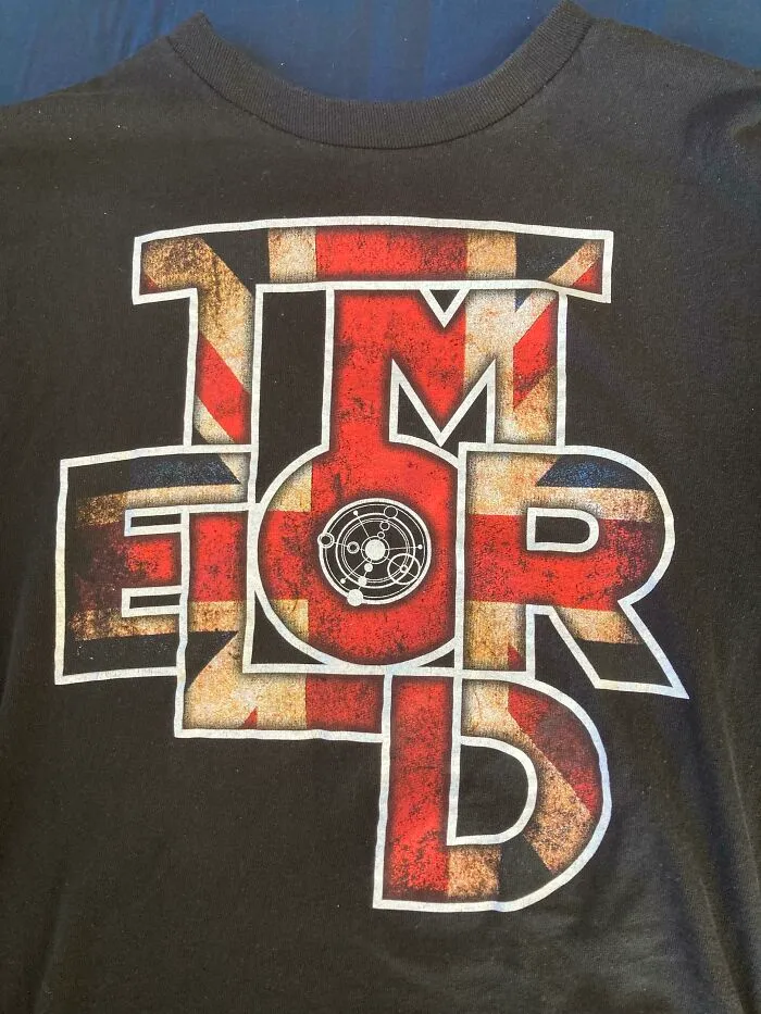 A black t-shirt with the word 'TMEORD' in a British flag pattern. An example of bad clothing designs.