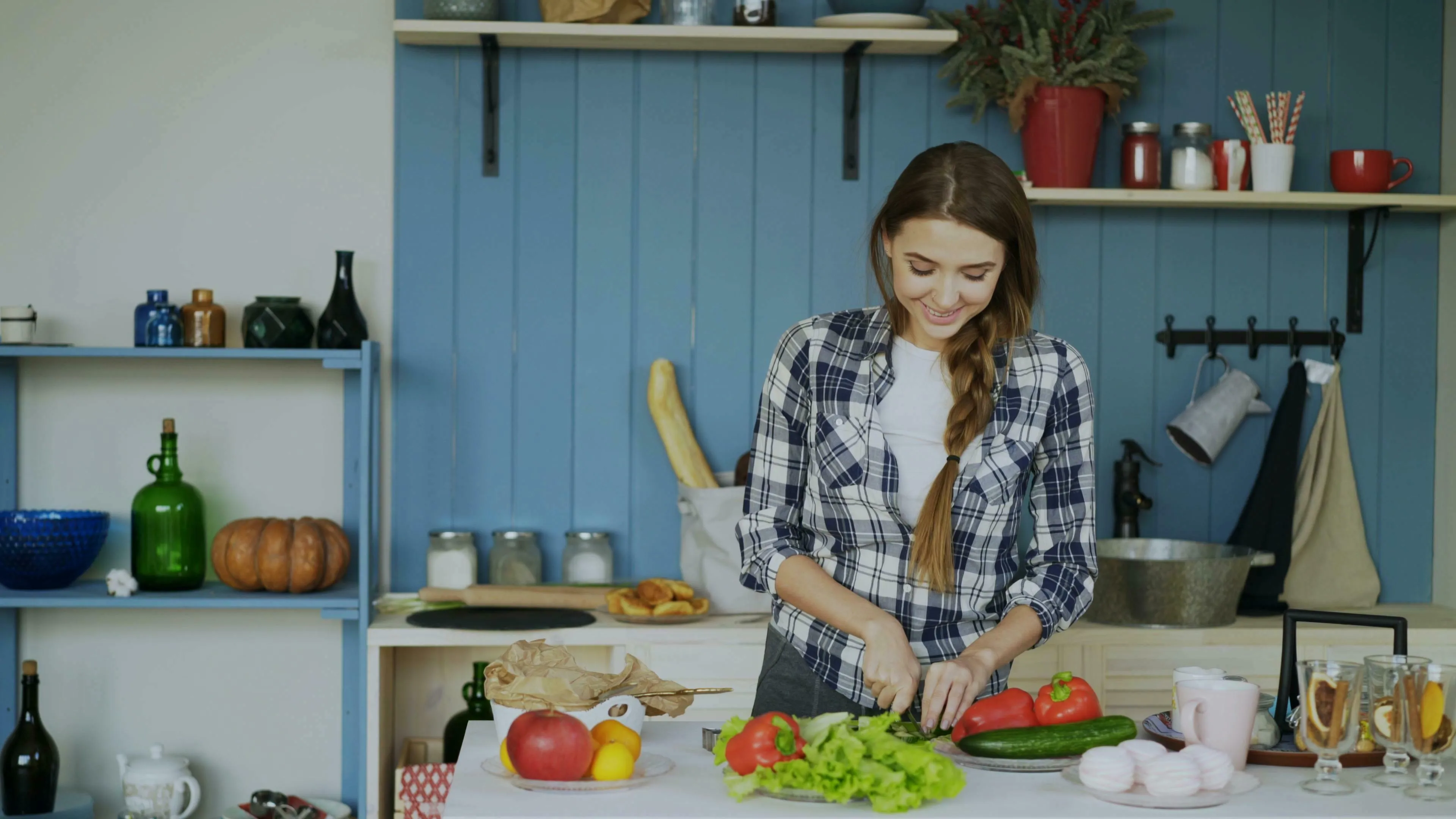 Smiling woman chopping vegetables in a kitchen. She experiences joy from the cooking experience.