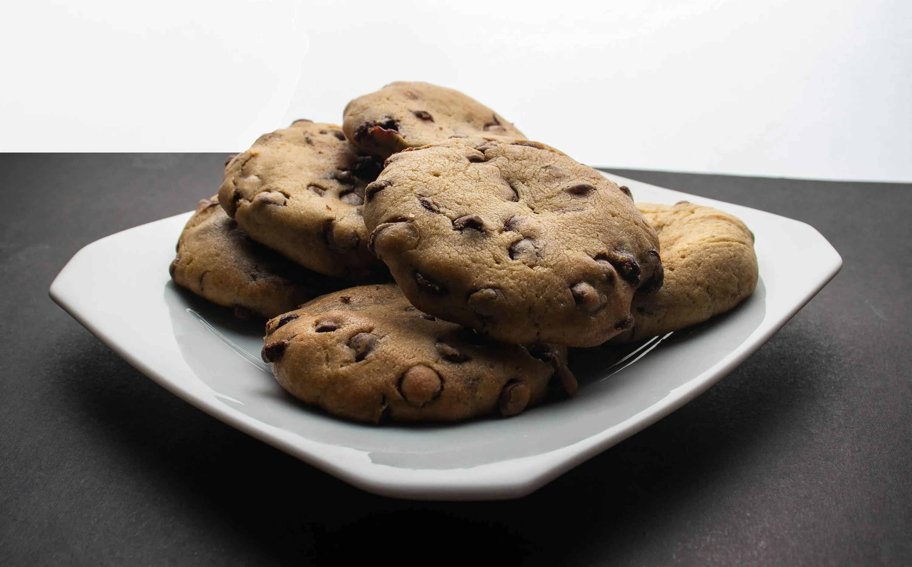A plate of delicious homemade cookies, perfect for a snack, with chocolate chips visible on their golden-brown surface.