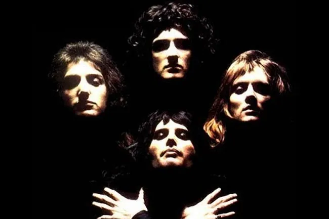 Iconic band Queen in a dark, dramatic shot. This image brings to mind the joy of Bohemian Rhapsody.
