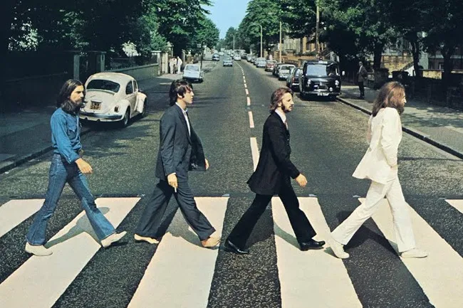 The Beatles walking across a crosswalk on Abbey Road, a song associated with joy like Here Comes the Sun.