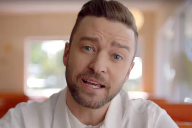 Justin Timberlake, with blue eyes and a beard, singing Can't Stop the Feeling, a song associated with joy.