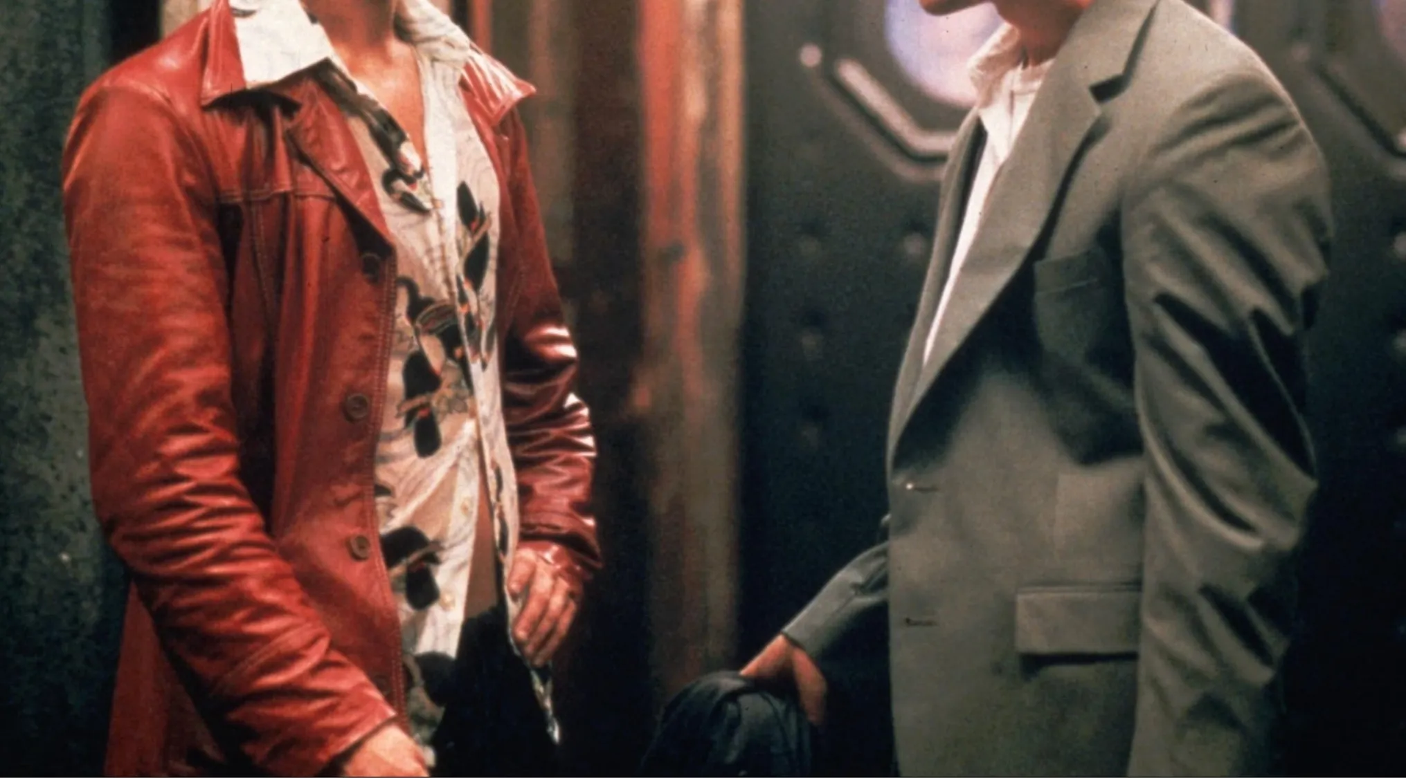 Two men, one in a red leather jacket and patterned shirt, the other in a gray suit. Iconic outfits from movies.