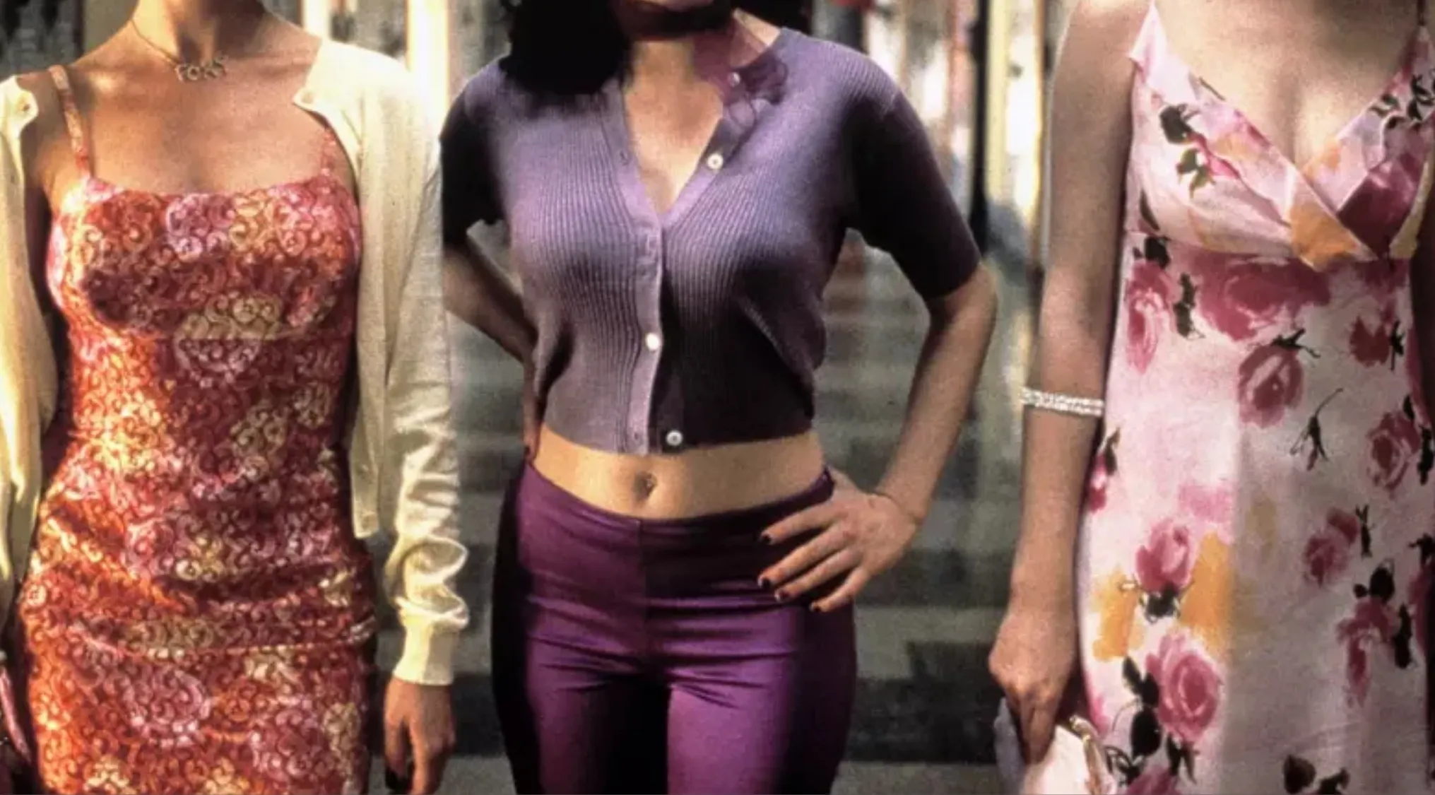 Three women showcasing iconic outfits from movies. Y2K fashion featuring dresses, a crop top, and colorful pants.