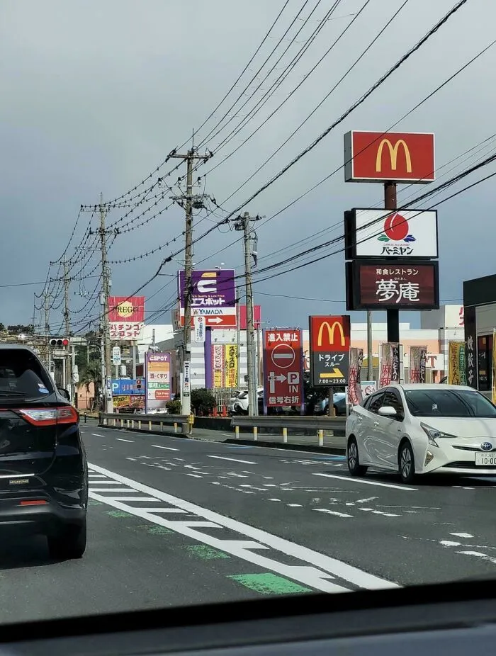 Traffic and commercial signs including McDonald's in urban hell cityscape