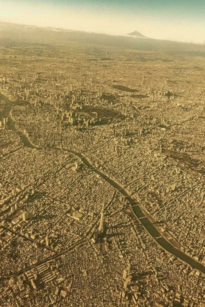 Aerial view of a densely populated urban cityscape with rivers and many buildings