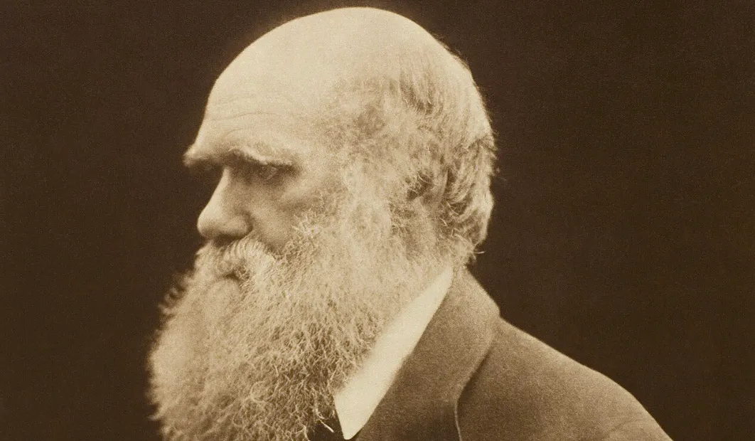 Sepia-toned profile of Charles Darwin with a long white beard. Test your general knowledge on science pioneers.