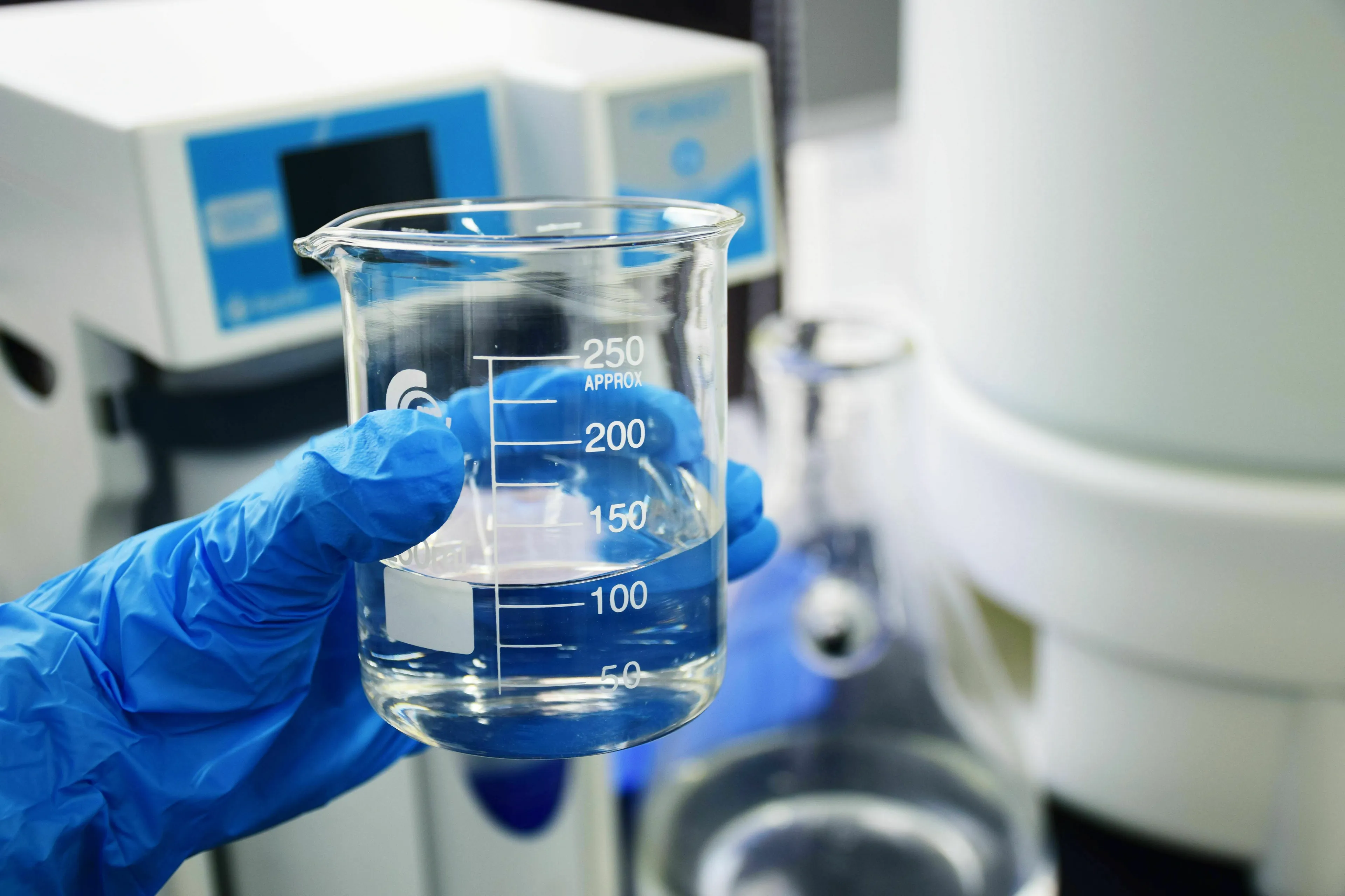 A gloved hand holds a beaker with a clear liquid, emphasizing general knowledge about substance pH.