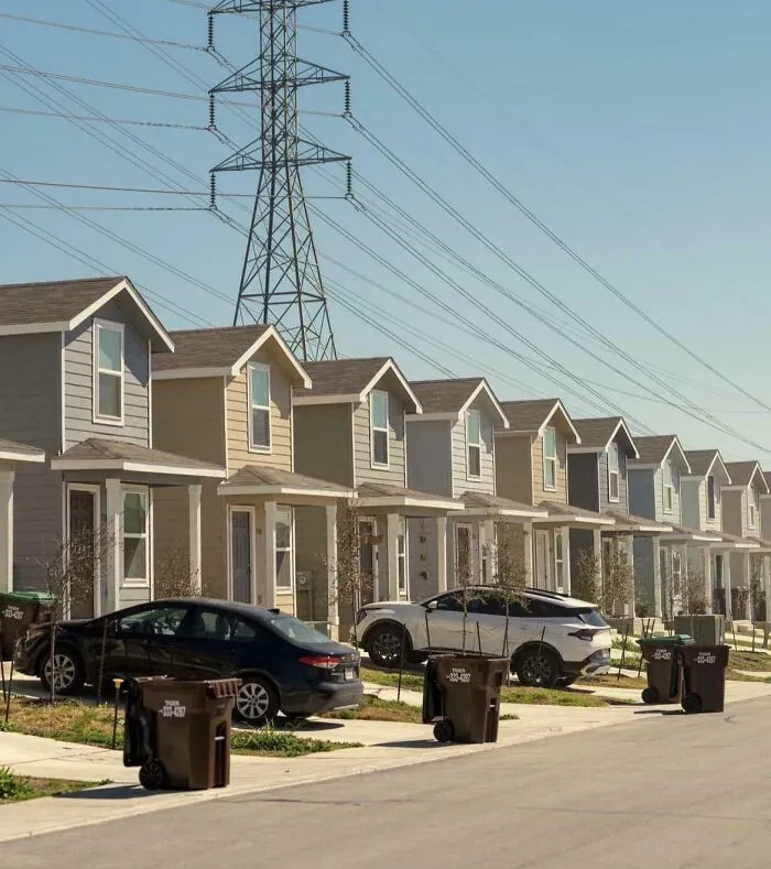 Row of suburban houses under high tension power lines in urban neighborhood