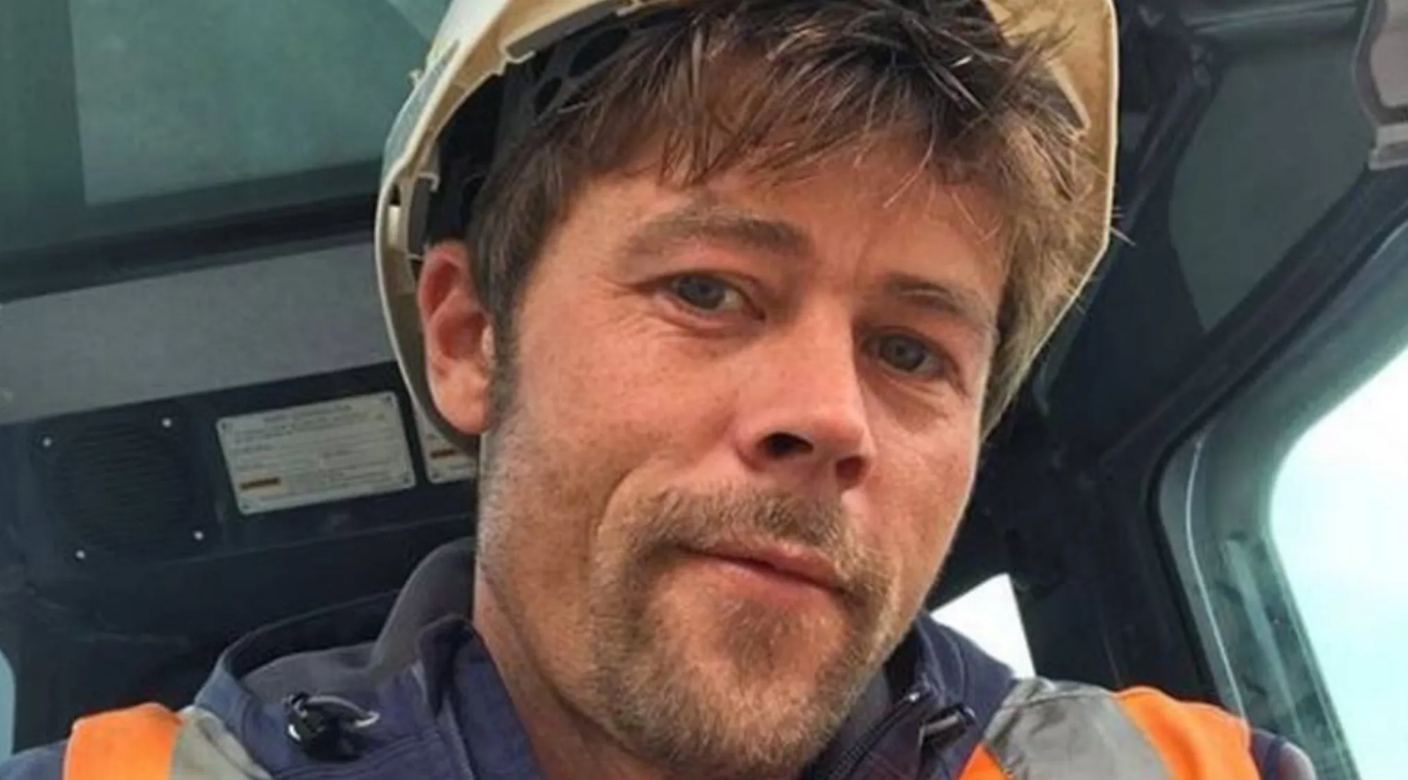 A man with a beard and mustache wearing a hard hat, resembling a Celebrity Doppelganger, looking at the camera.