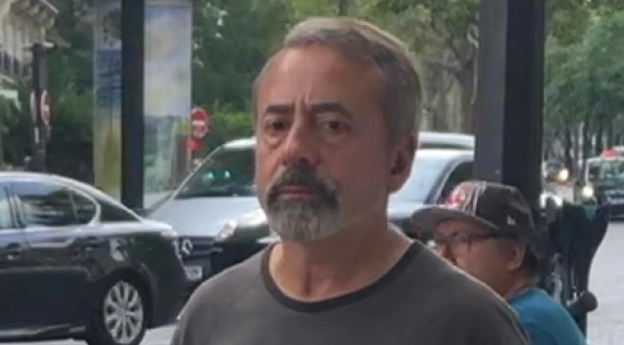 Man with graying hair and beard, wearing a grey shirt, looking directly at the camera. Celebrity doppelgangers.