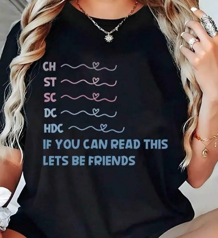 A woman wearing a black t-shirt with bad clothing designs that says 'IF YOU CAN READ THIS LETS BE FRIENDS'.