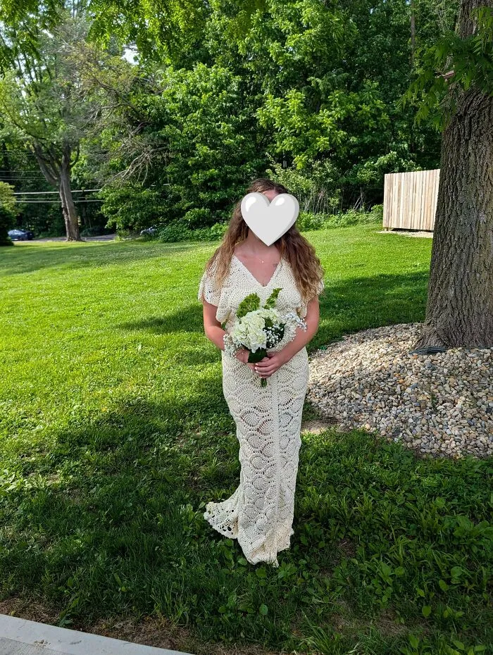 Woman wearing elegant crochet wedding dress outdoors