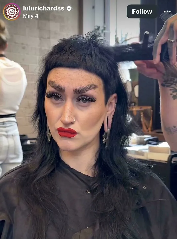 A woman with an extreme, short-bang hairstyle and bold makeup at a hair salon, portraying a hair salon disaster.