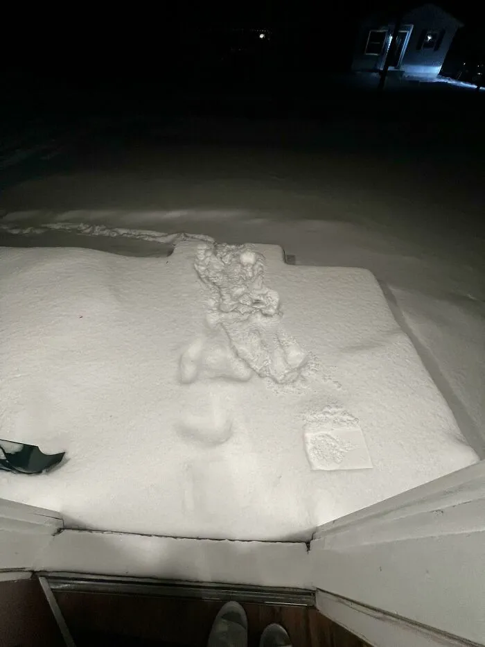 Deep snow covers a doorstep, showing a challenging food delivery scenario.