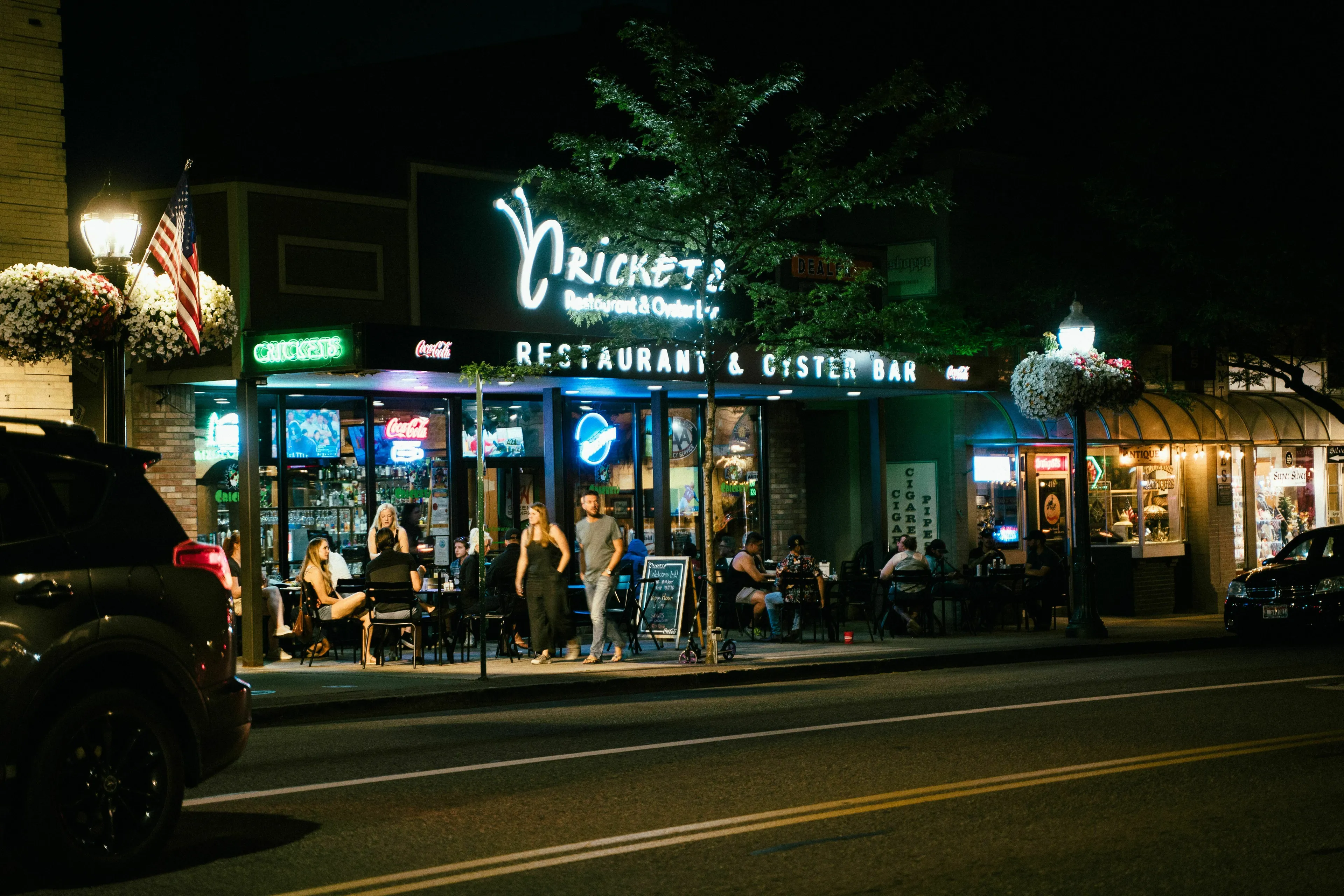 Night scene of a lively restaurant and oyster bar. Patrons dine al fresco. How extroverted are you?