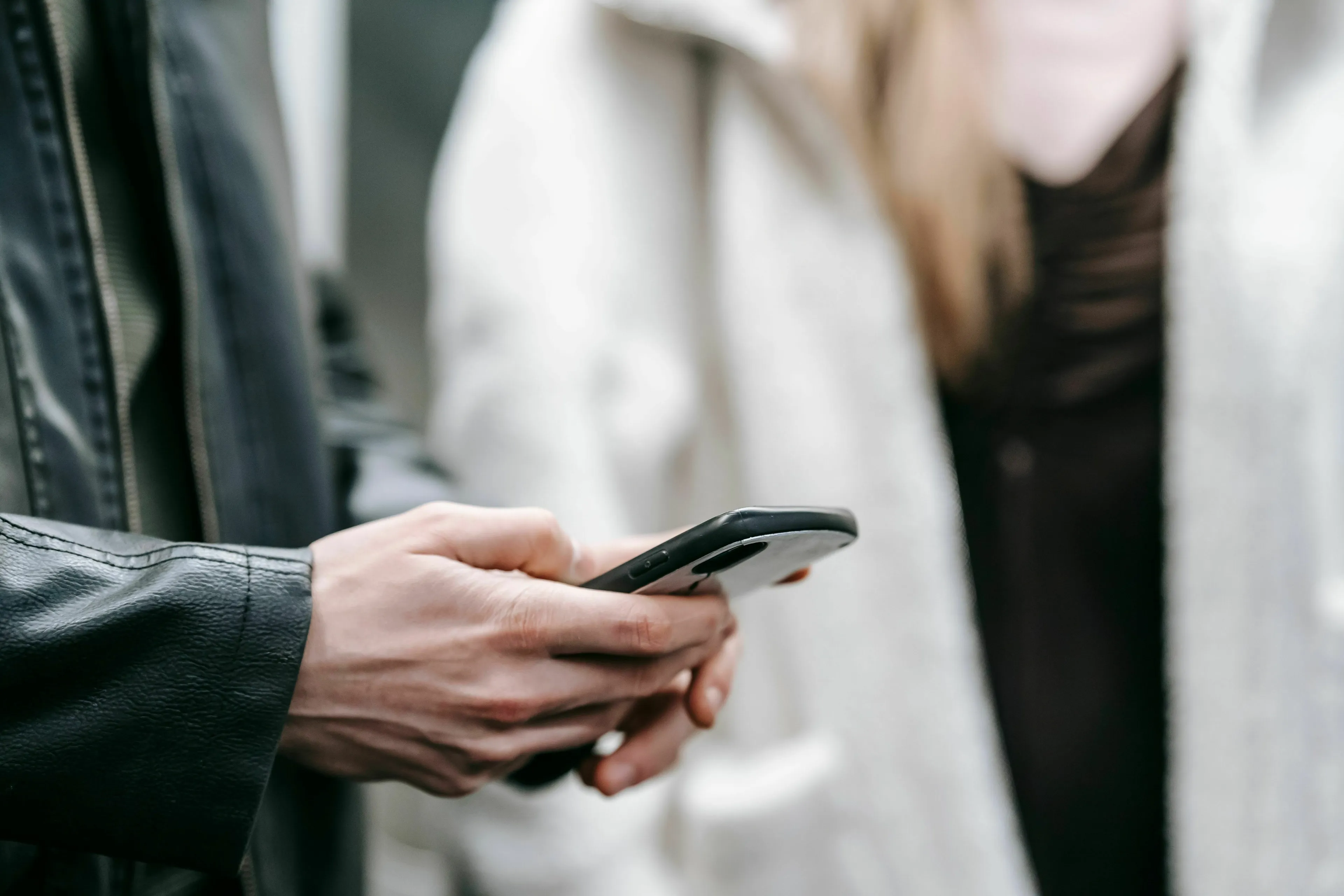 Close-up of hands typing on a smartphone, indicating how extroverted you are or your texting style.