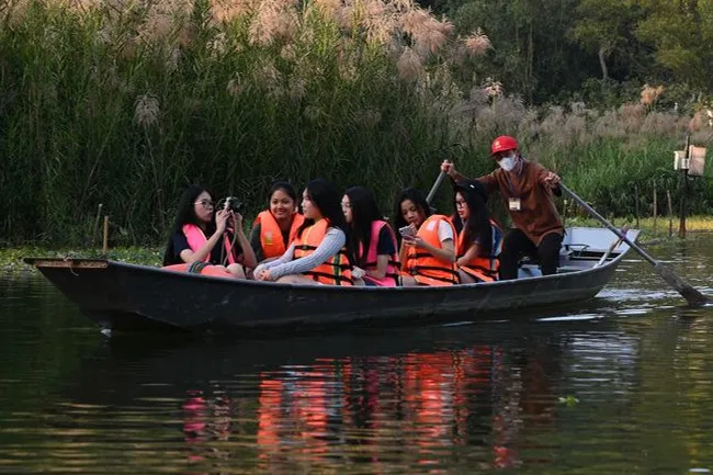 Women in life vests on a group tour boat with a guide, enjoying built-in activities on a serene river.