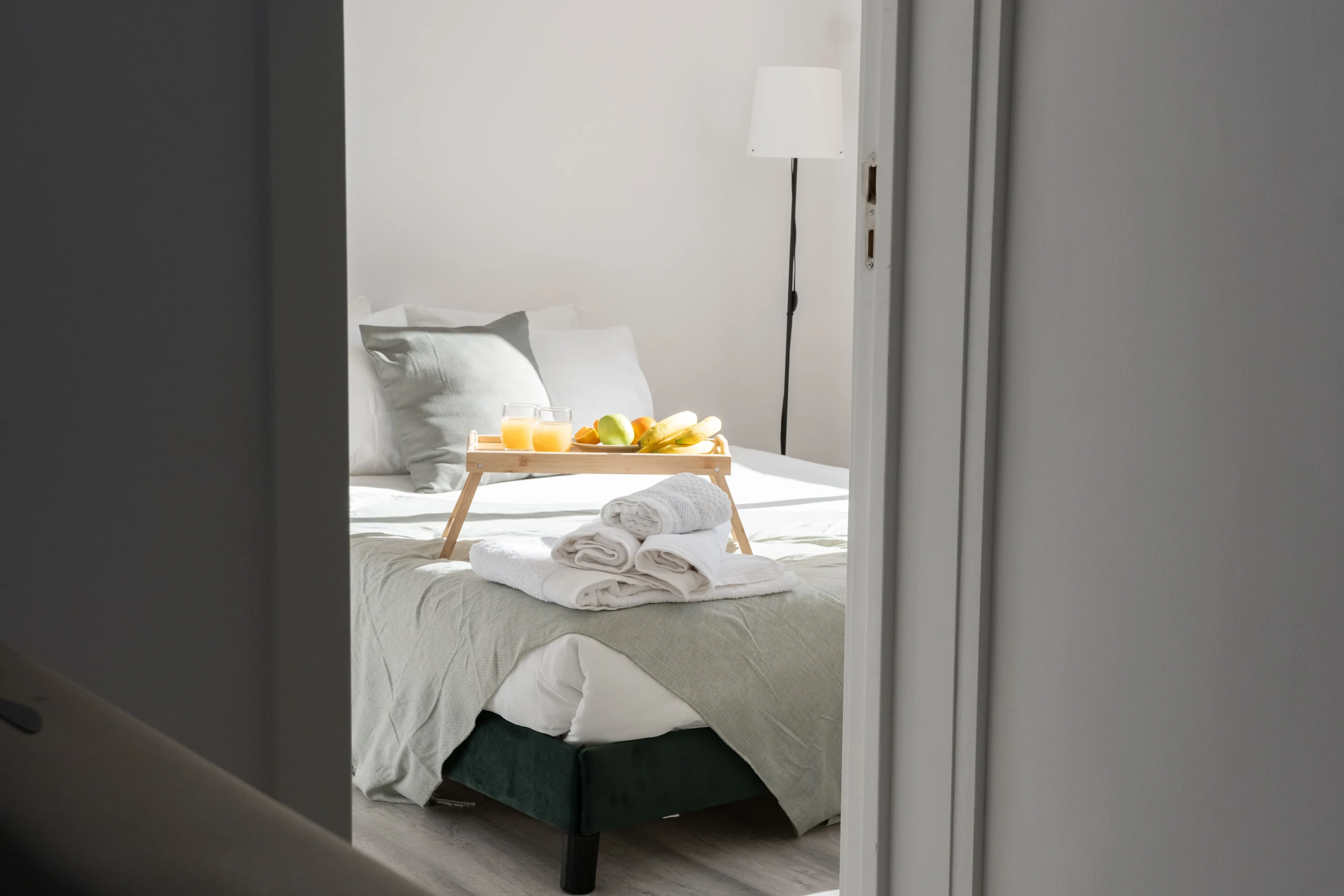 A cozy B&B room with breakfast in bed and fresh towels, perfect for a relaxing vacation style.