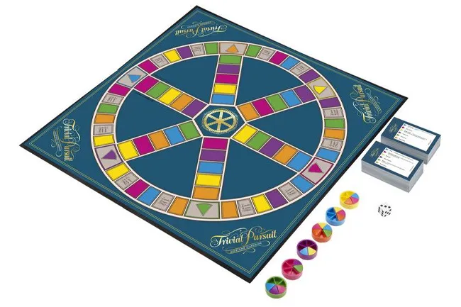 An overhead shot of the Trivial Pursuit board game, showing the blue board, colorful game pieces, question cards, and dice.