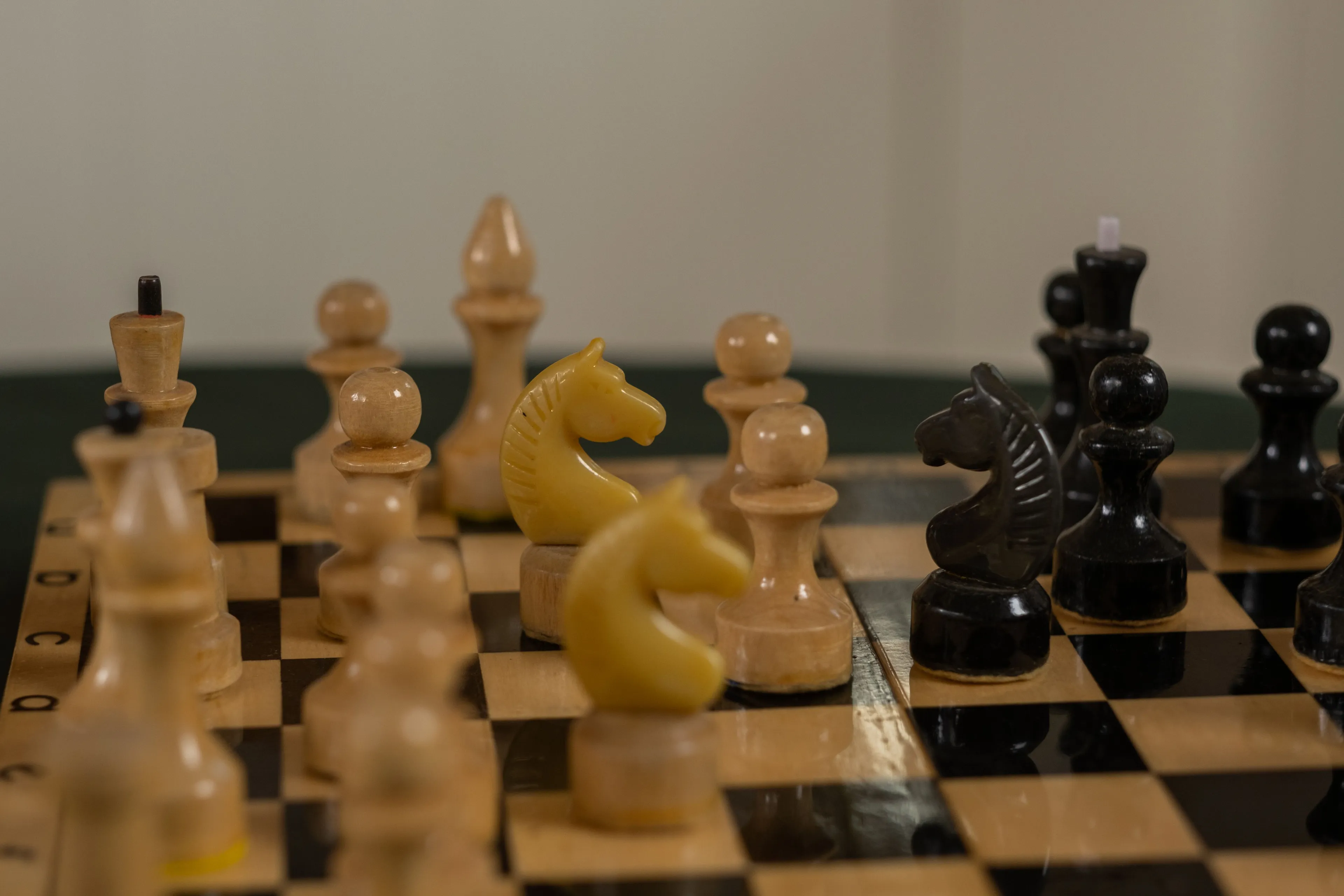 A close-up of a chess board with white and black pieces, highlighting knights and pawns in a strategic setup.