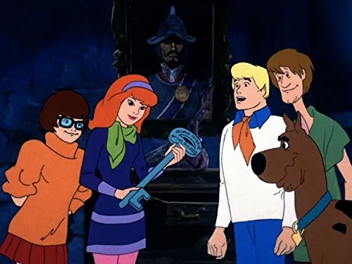 The Scooby-Doo gang in a spooky setting. Daphne holds a large key, while Velma, Fred, Shaggy, and Scooby look on.