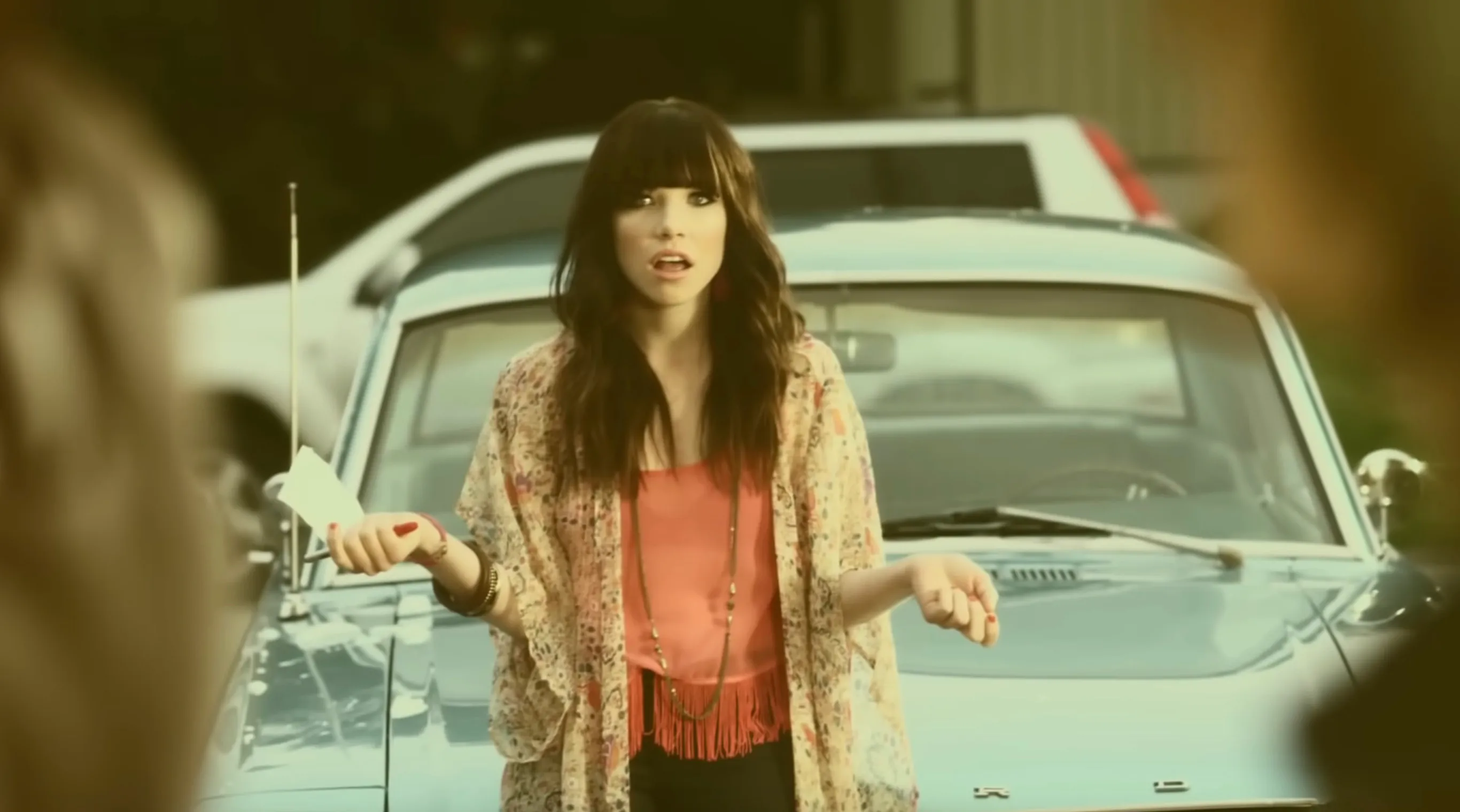 Carly Rae Jepsen looking surprised in front of a blue car. Pop Culture From A To Z Quiz.