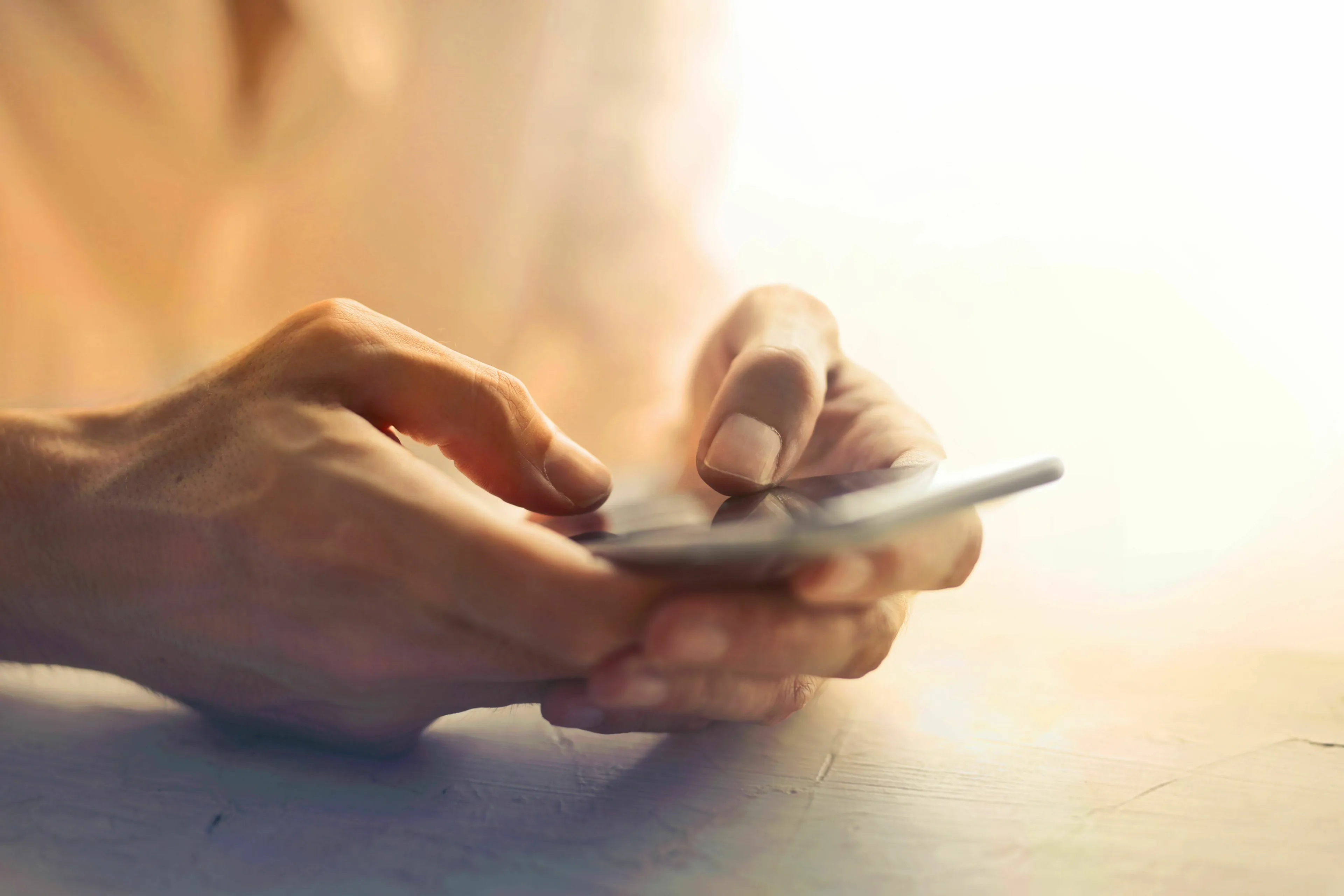 Close-up of hands holding and typing on a smartphone, suitable for a pop culture quiz on social media platforms.