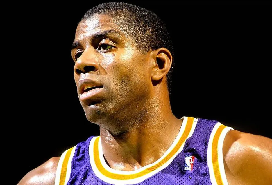 Magic Johnson looking focused, wearing a purple and yellow Lakers jersey against a dark background. Basketball G.O.A.T.