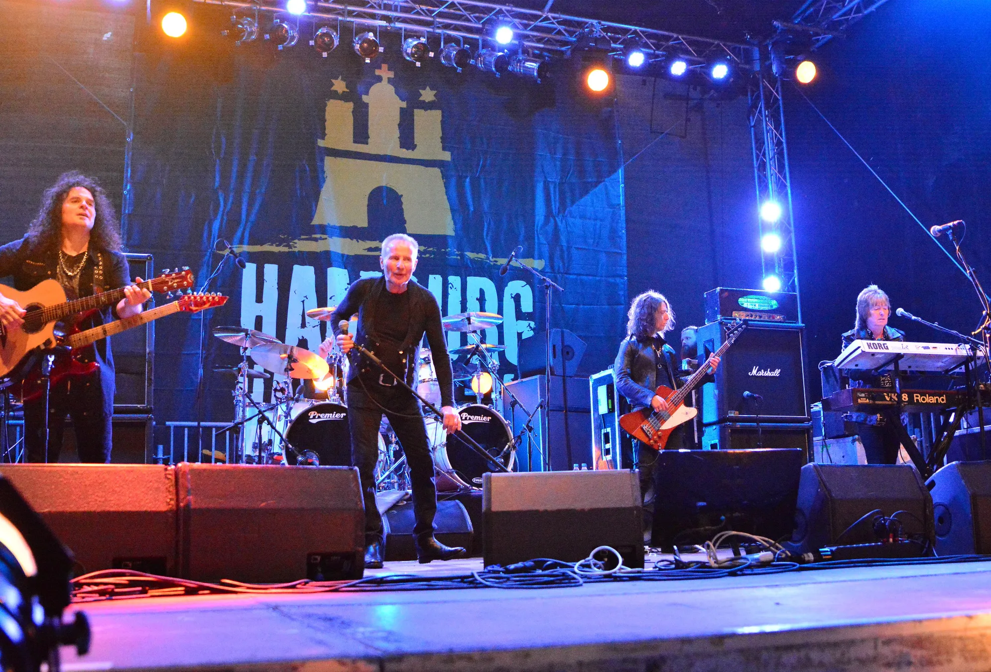 UFO, the Irish rock band, performs live on stage under bright lights with a large backdrop.