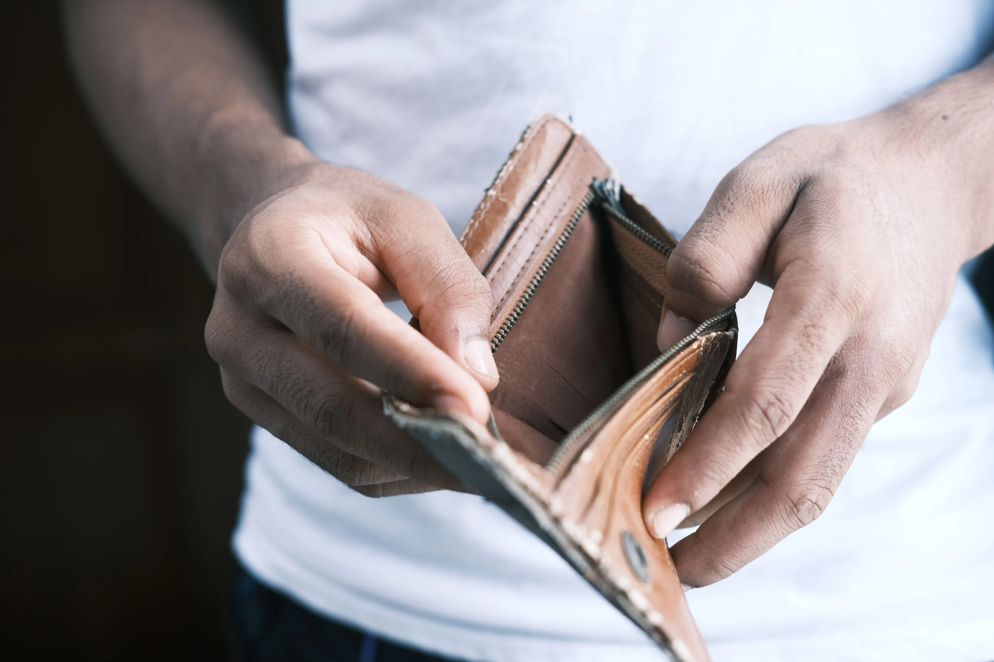 A person holds an empty wallet, symbolizing the fear of loss of stability and financial insecurity.