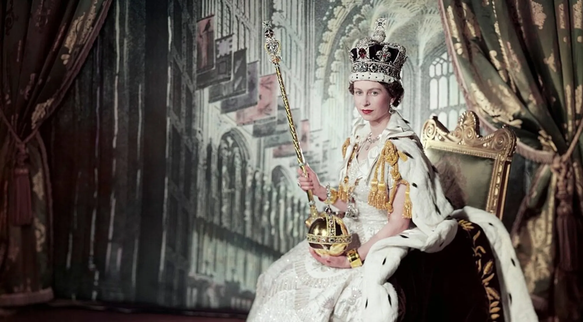Queen Elizabeth II, the longest-reigning British monarch, in full coronation regalia, holding the scepter and orb.