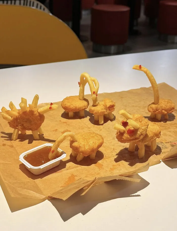 Dinosaur figures made from chicken nuggets and fries, a creative yet questionable food combo.