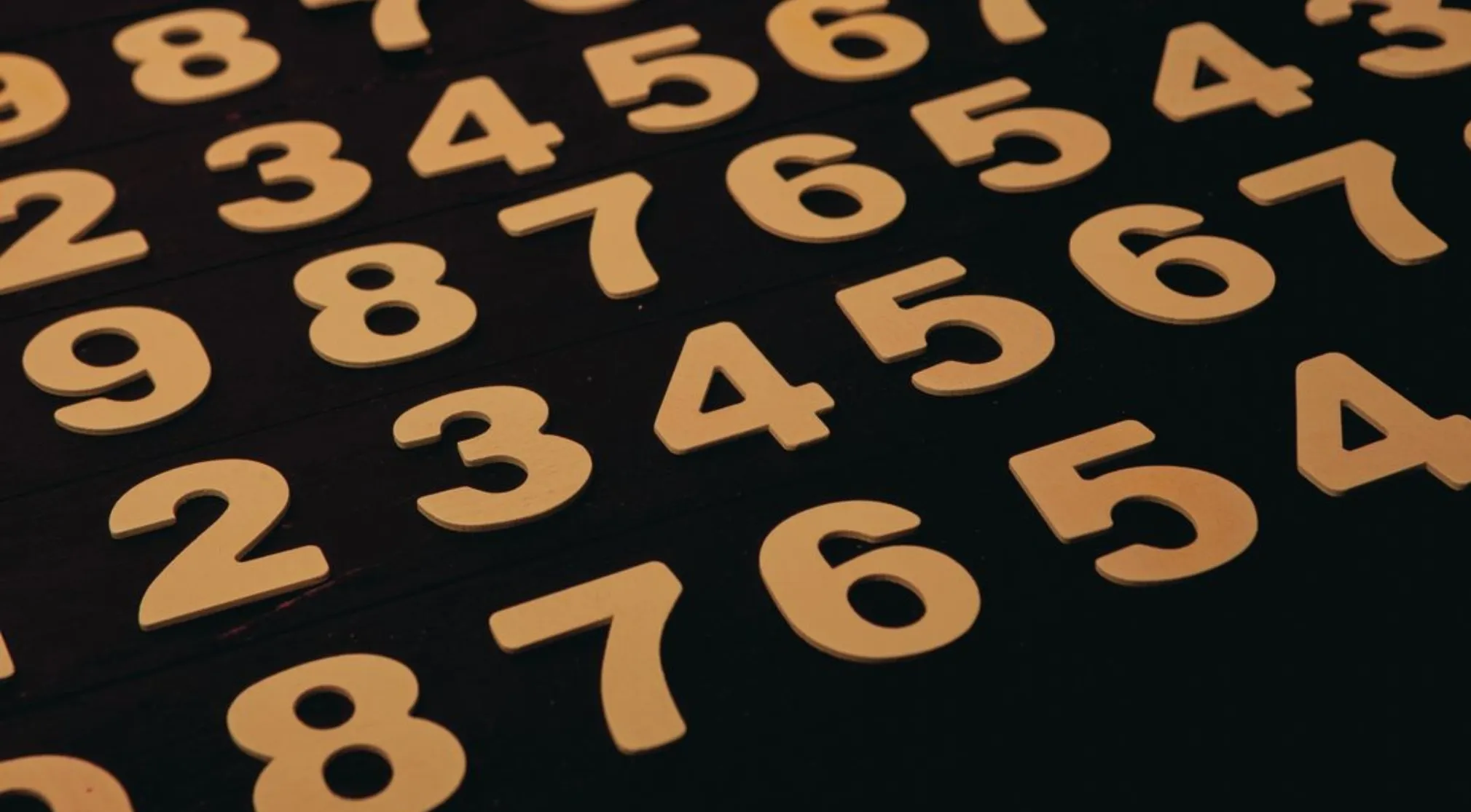 Scattered wooden numbers 2, 3, 4, 5, 6, 7, 8, 9 on a dark surface, representing basic math concepts. What is the only even prime number?