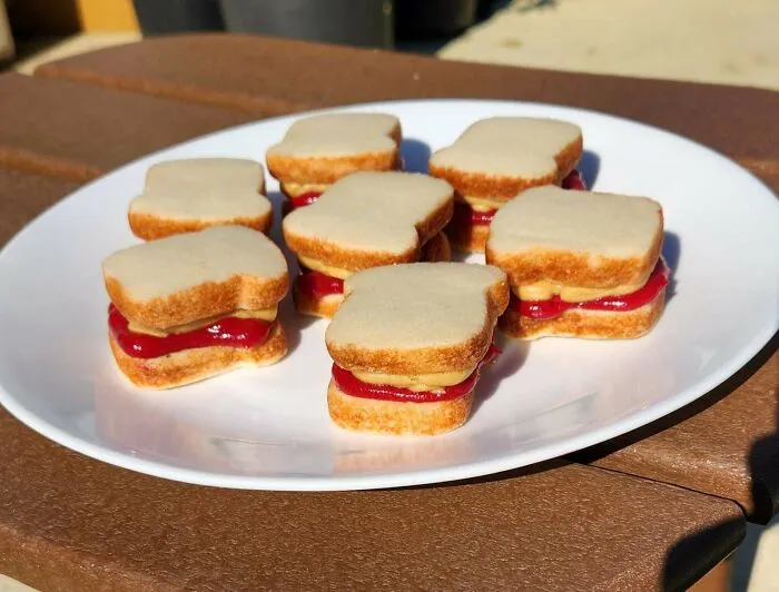 Mini peanut butter and jelly sandwich cookies on a white plate, amazing and delicious treats by bakers.