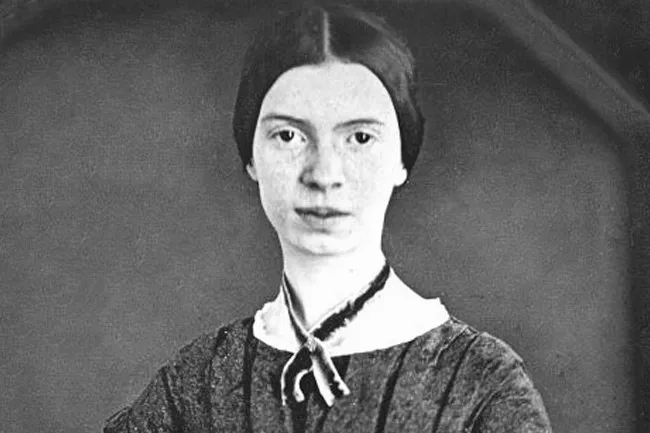 A striking black and white portrait of Emily Dickinson, a historical figure, gazing directly at the viewer.