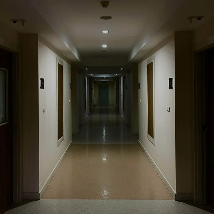 A long, dimly lit hallway in an unsettling building, depicting a classic liminal space.