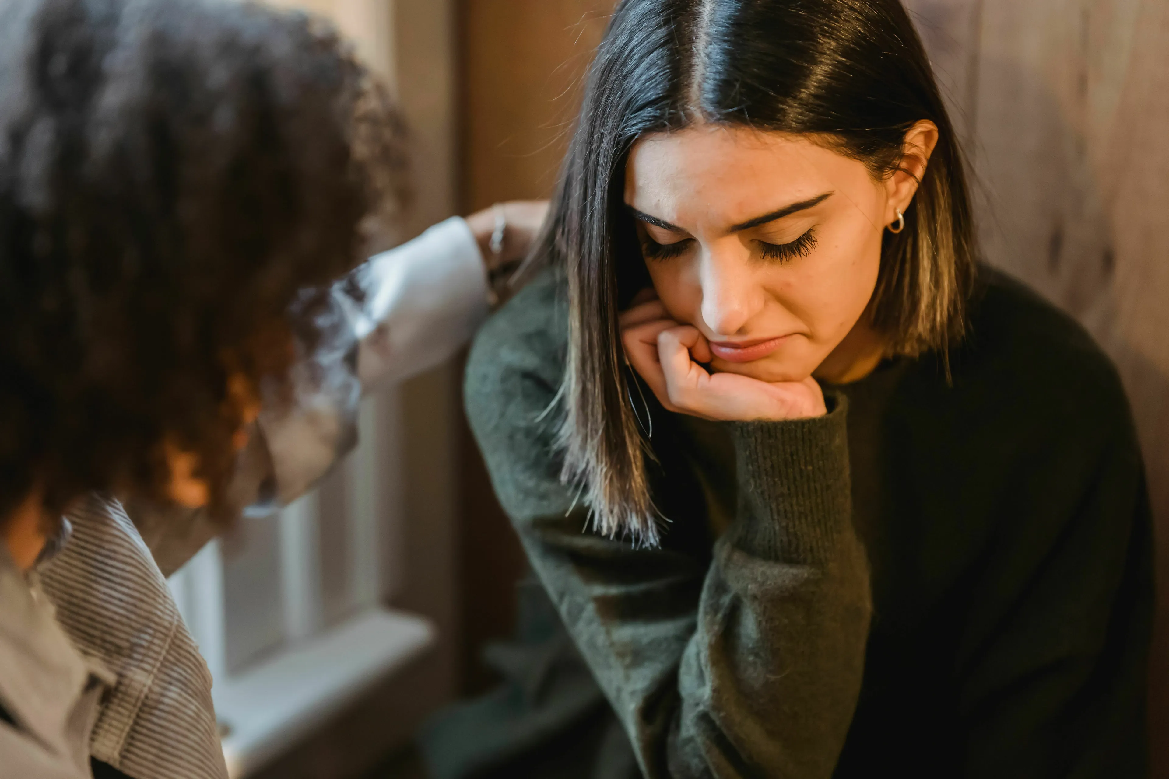 A friend comforting another friend who is sad and looking down. This is your Red Flag.