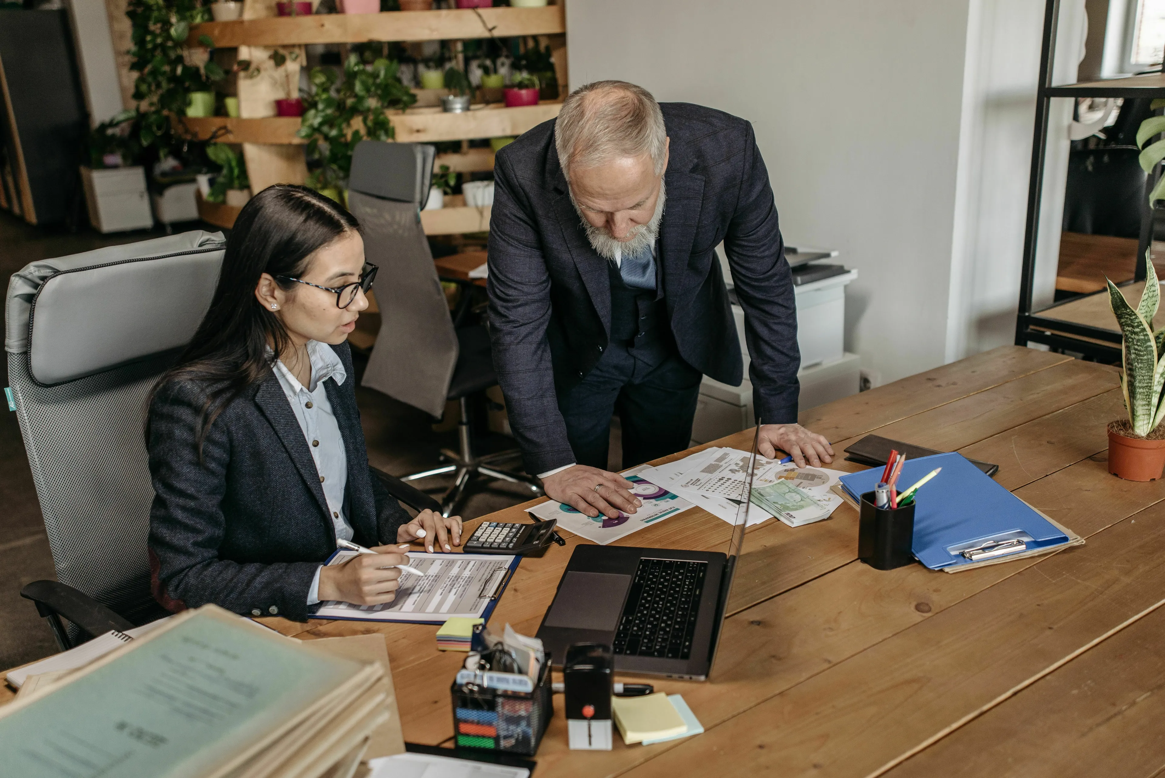 A boss gives vague feedback to an employee. They are at a desk reviewing documents. What's your red flag?