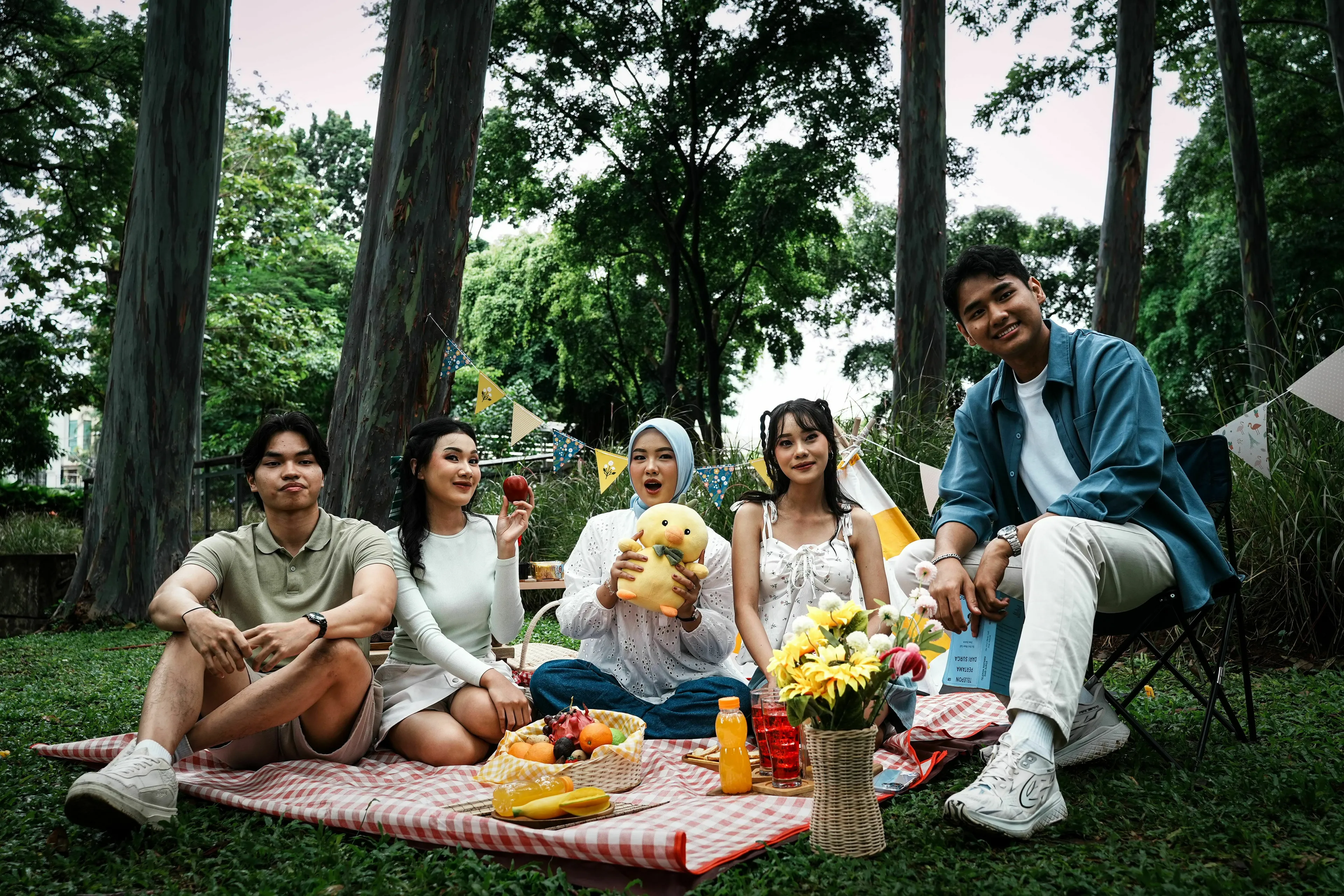 A diverse group of friends enjoying a picnic outdoors. They are smiling and interacting, exploring their red flag traits and friend group roles.