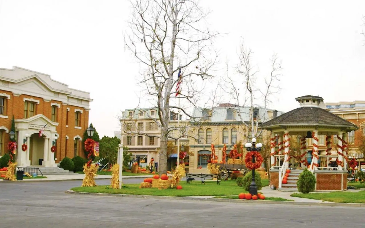 Stars Hollow town square, decorated for autumn with pumpkins and wreaths. A gazebo stands prominently.