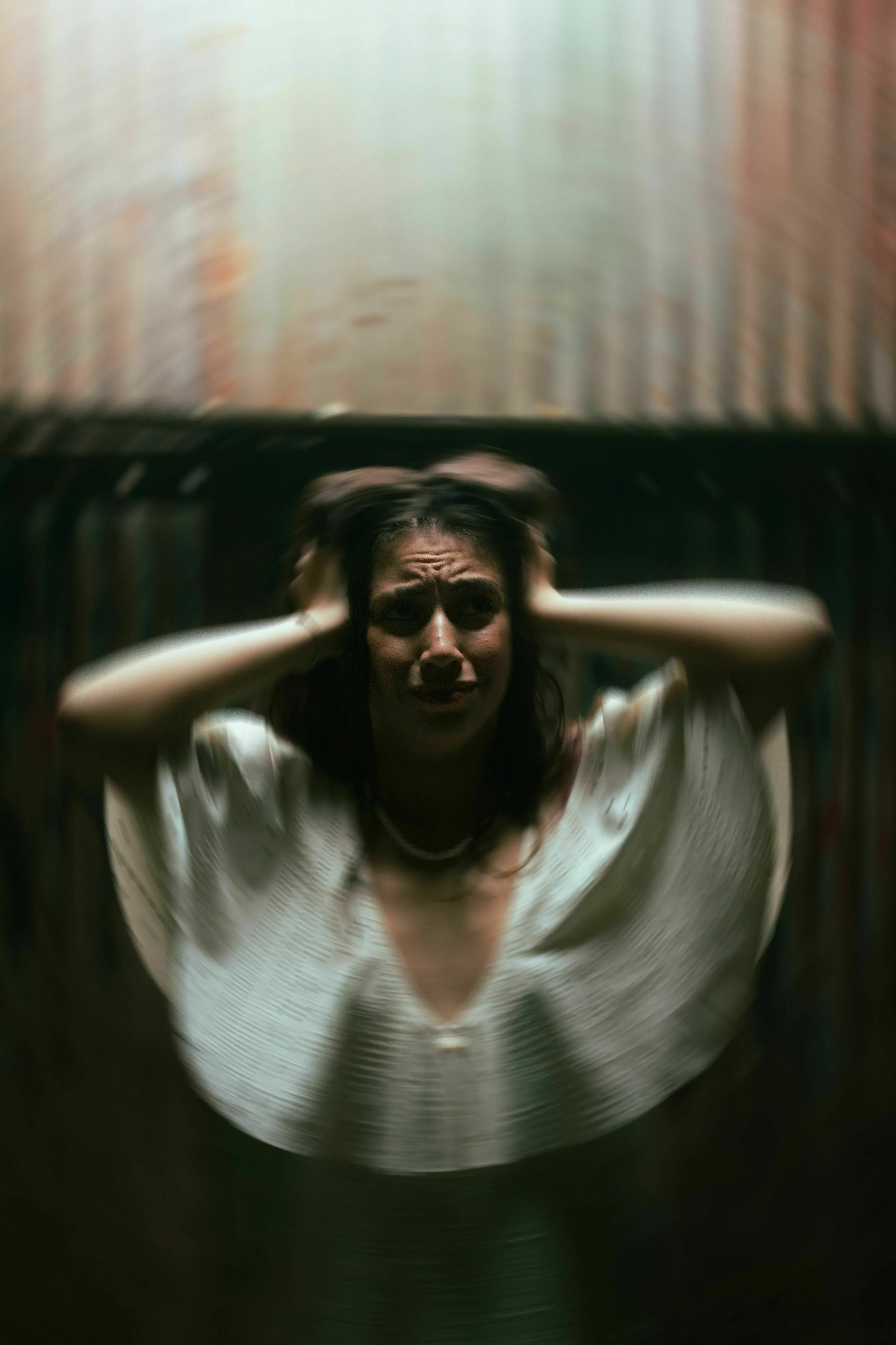 A woman with an expression of fear, hands grasping her head, blur effect around her. General Knowledge Type-In.