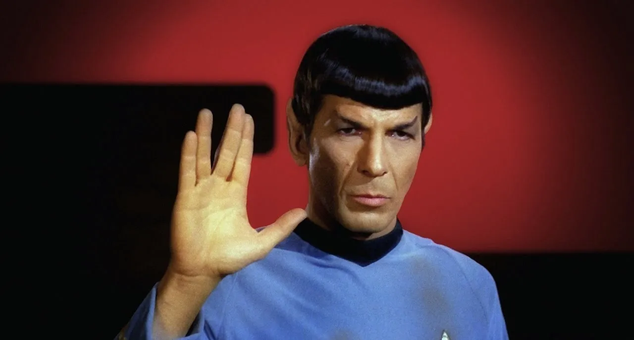 Spock from Star Trek in his iconic blue uniform, giving the Vulcan salute, wishing to live long and prosper.