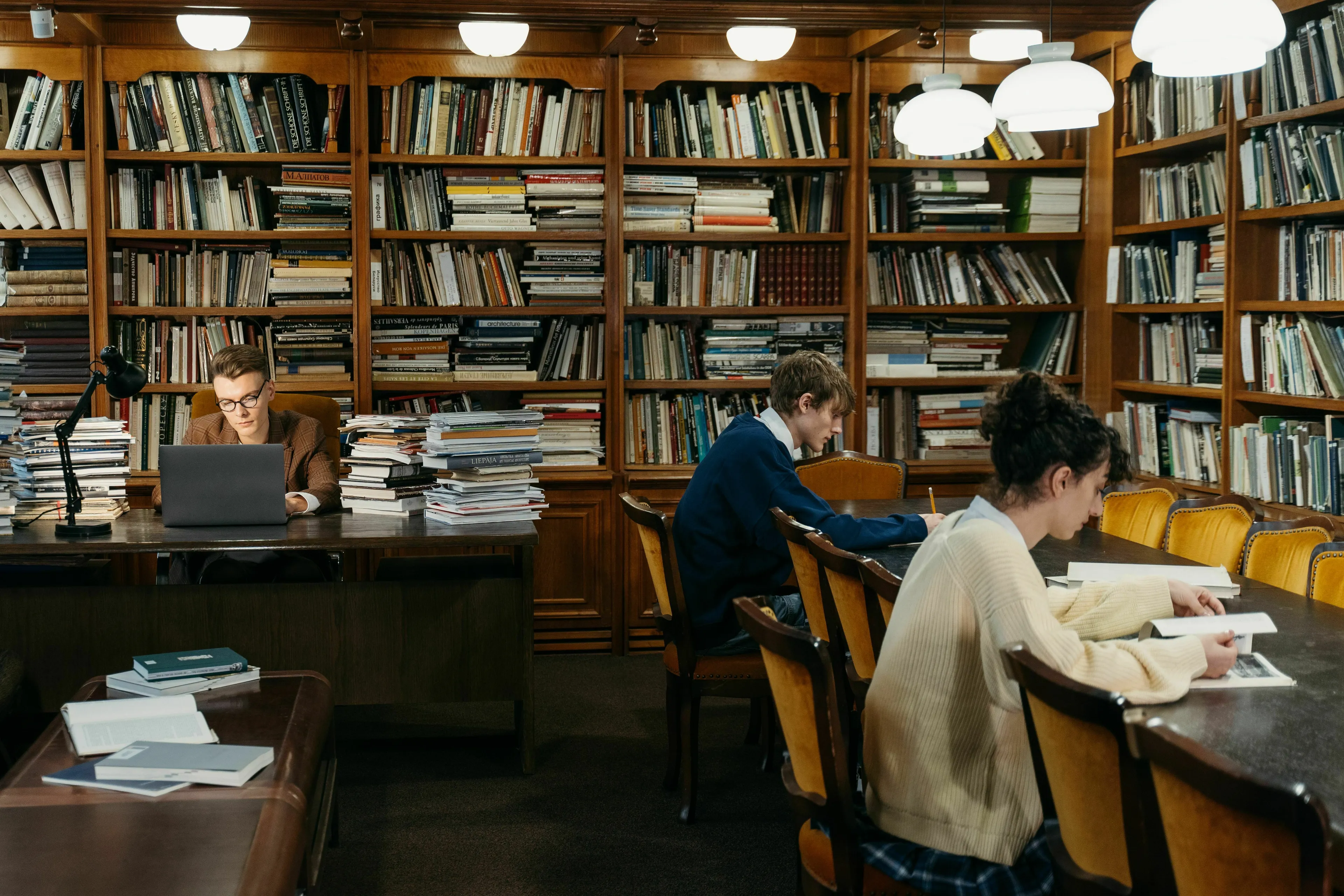 Students studying in a library, surrounded by bookshelves. Test your general knowledge and IQ.
