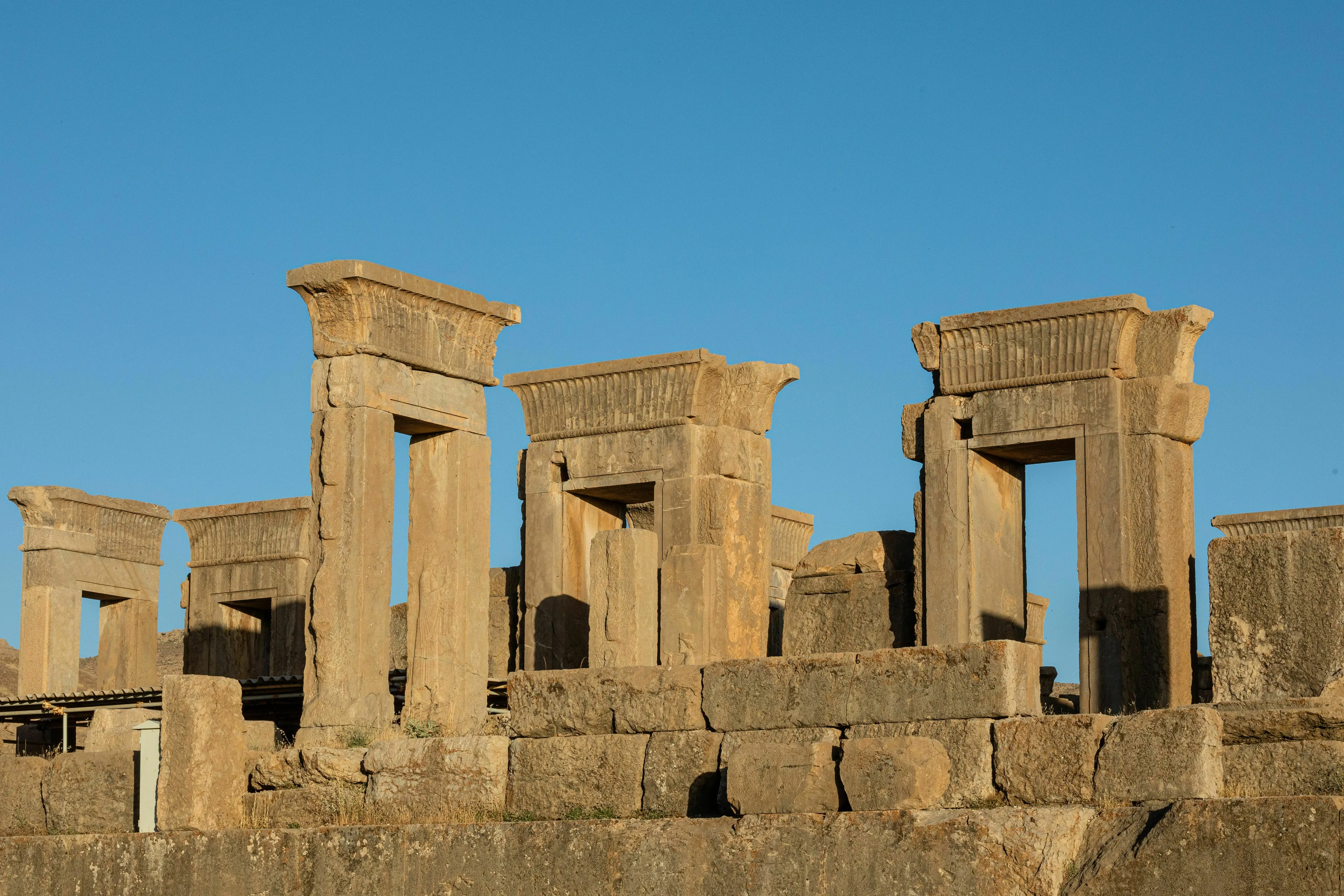Ancient stone ruins under a clear blue sky. A historical site from a country formerly known as Persia for a General Knowledge Test.
