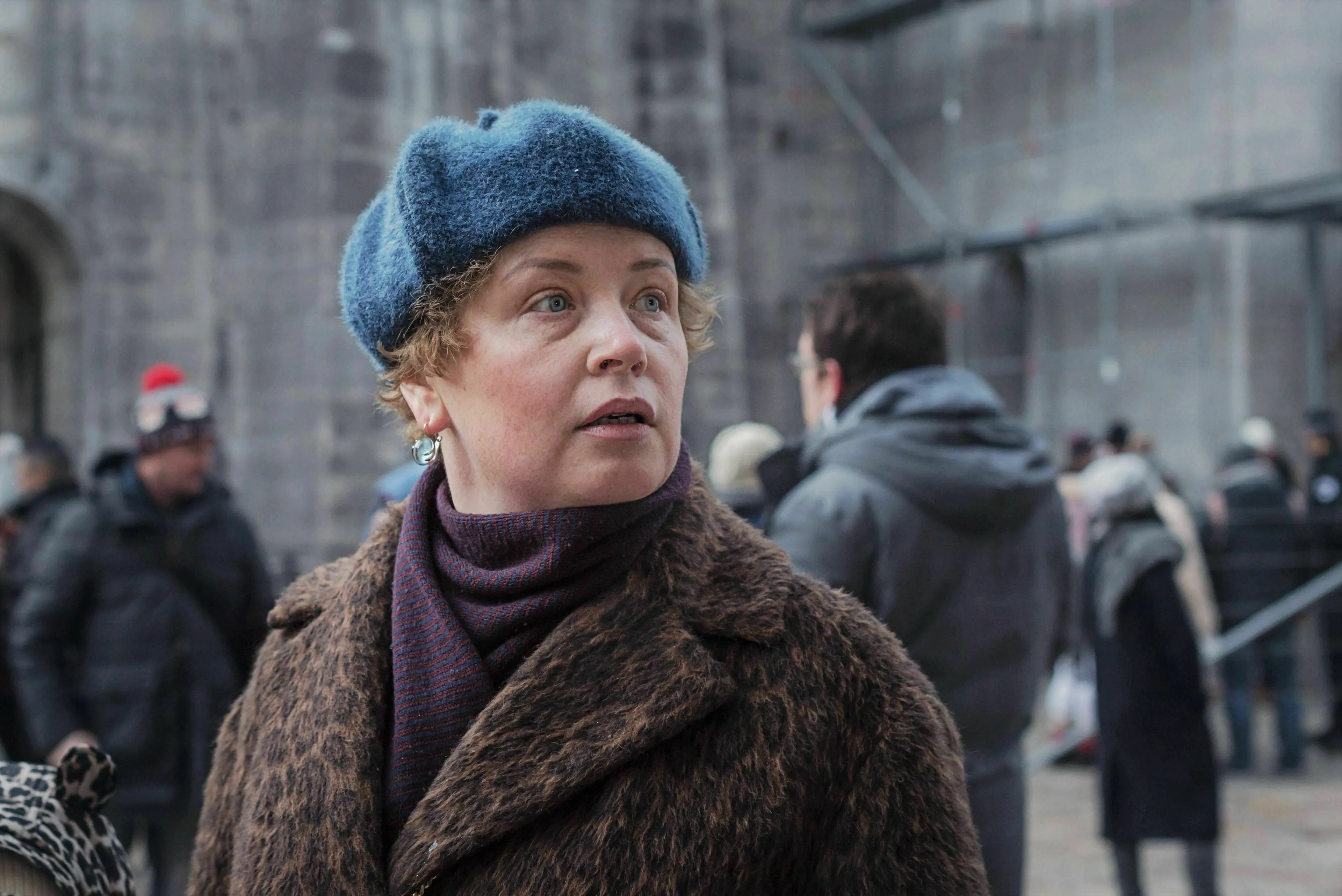 Woman in a blue fur hat and fur coat, portraying the Madonna in a Fur Coat character